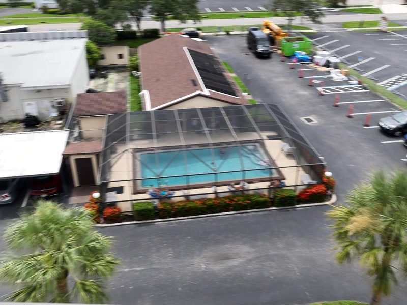 A building with a new roof and a screened pool enclosure